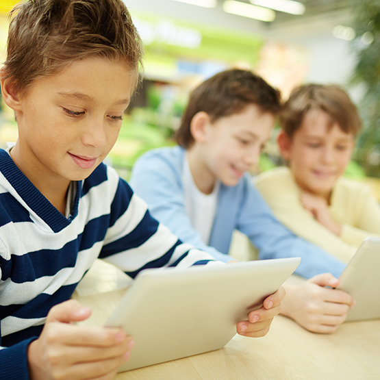 Schoolboys studying with touchpads